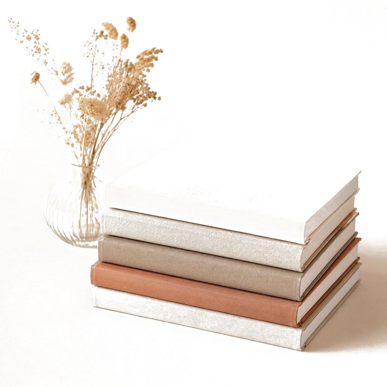 Livres et carnets empilés avec fleurs séchées représentant une structure claire
